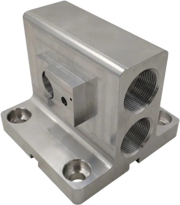 CNC machined aluminum manifold block with threaded ports and counterbored mounting holes.