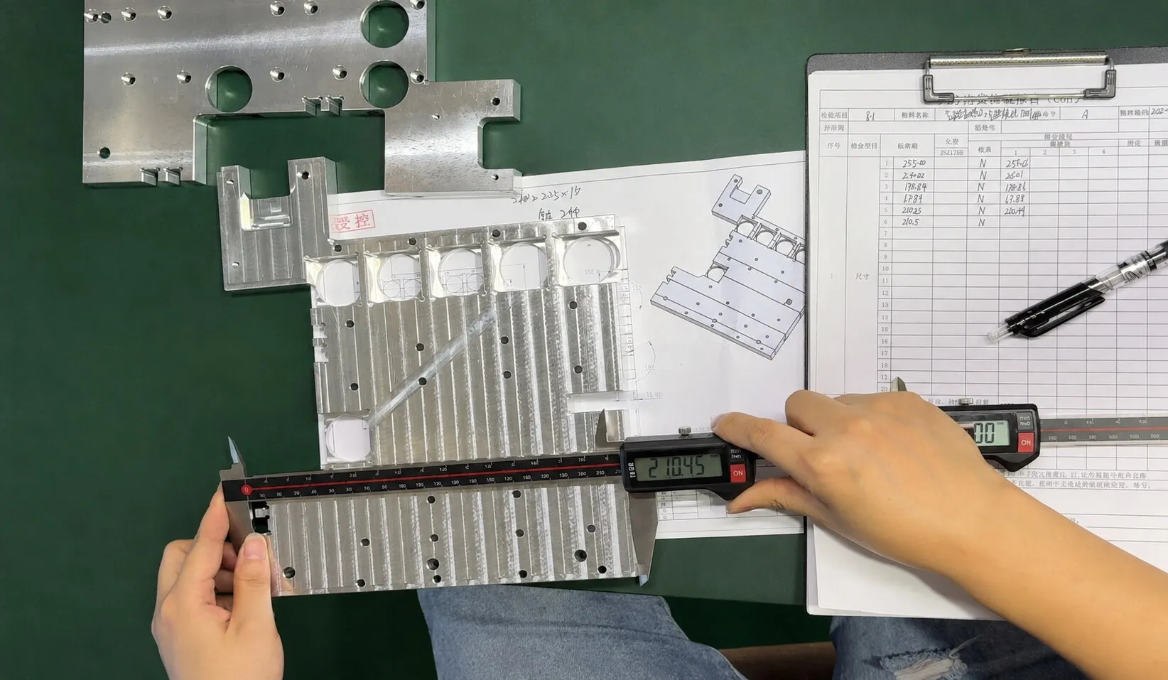 Inspector measuring a finished aluminum plate with calipers beside the inspection record sheet.