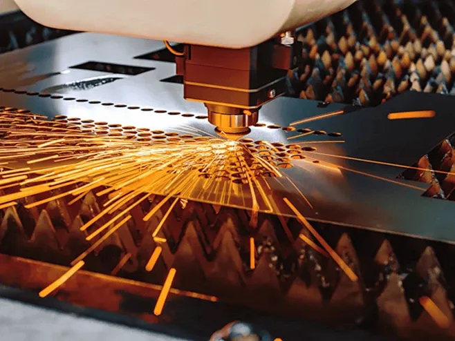 Laser cutting a sheet metal profile, throwing sparks.