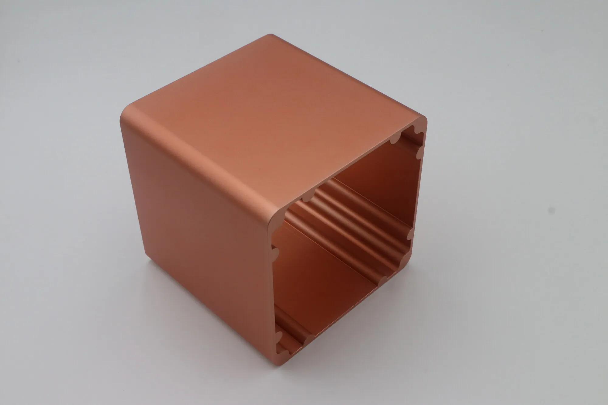 Close detail of an anodized aluminum extruded enclosure shell showing internal fins and machined edges