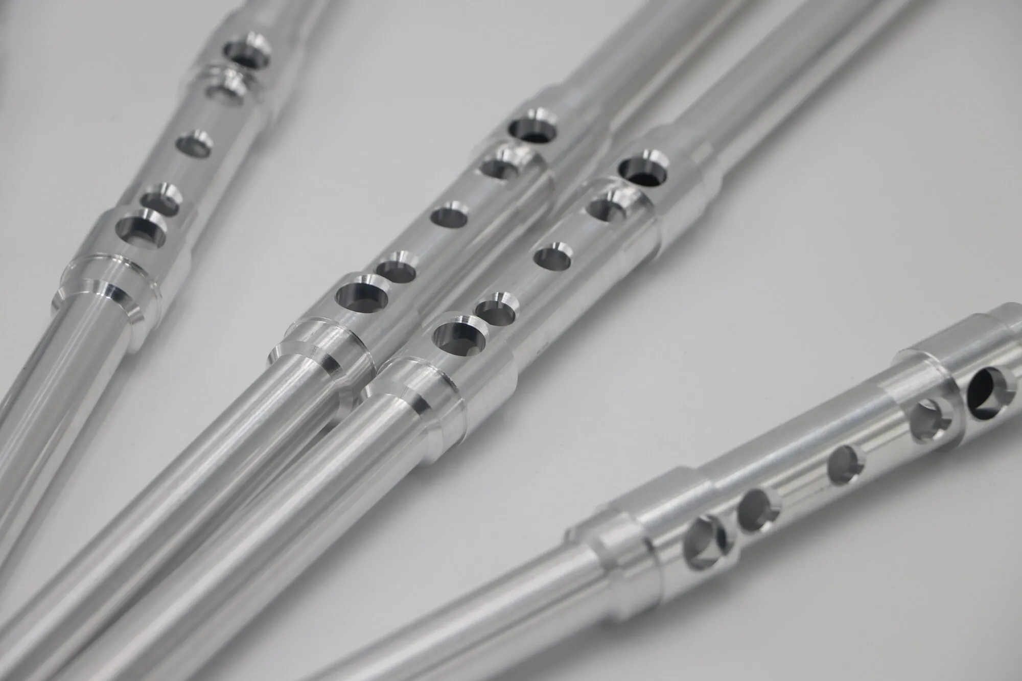 Close detail of counterbored holes machined along a polished slender tube