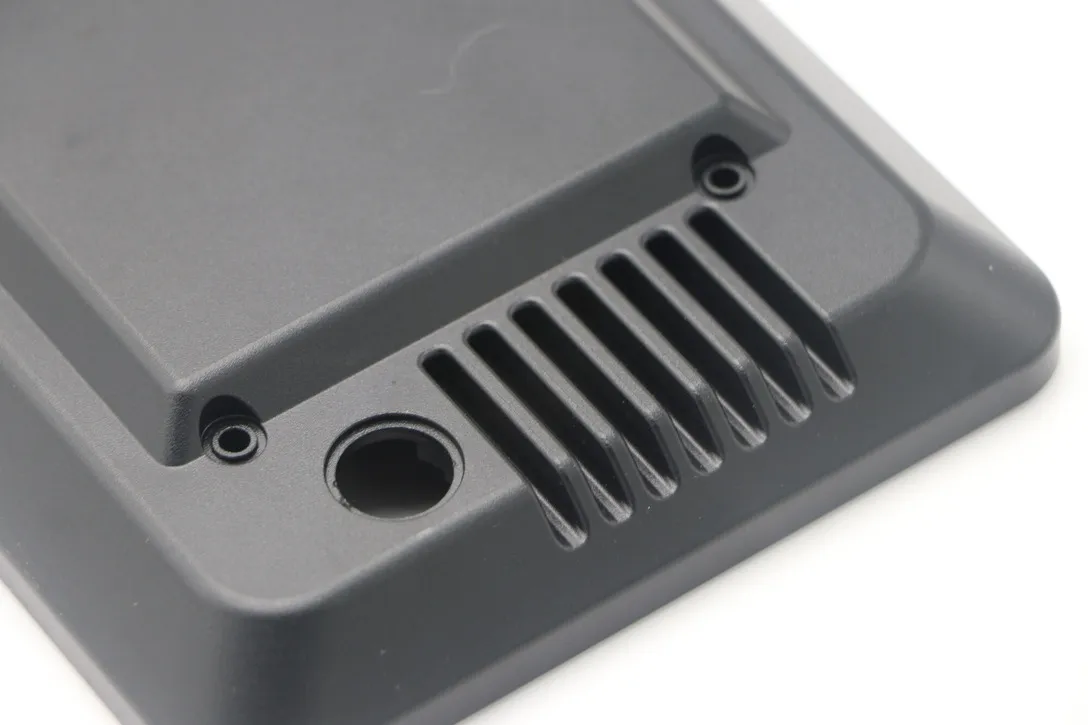 Close detail of milled vent slots and a sealing boss on a black anodized enclosure