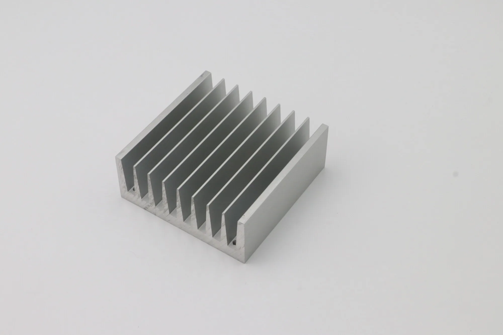 Extruded aluminum finned heat sink with drilled and tapped mounting face