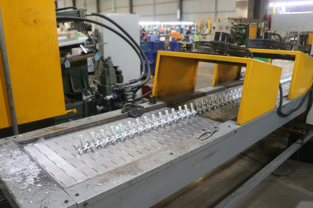 Aluminum components moving through a production-line handling stage