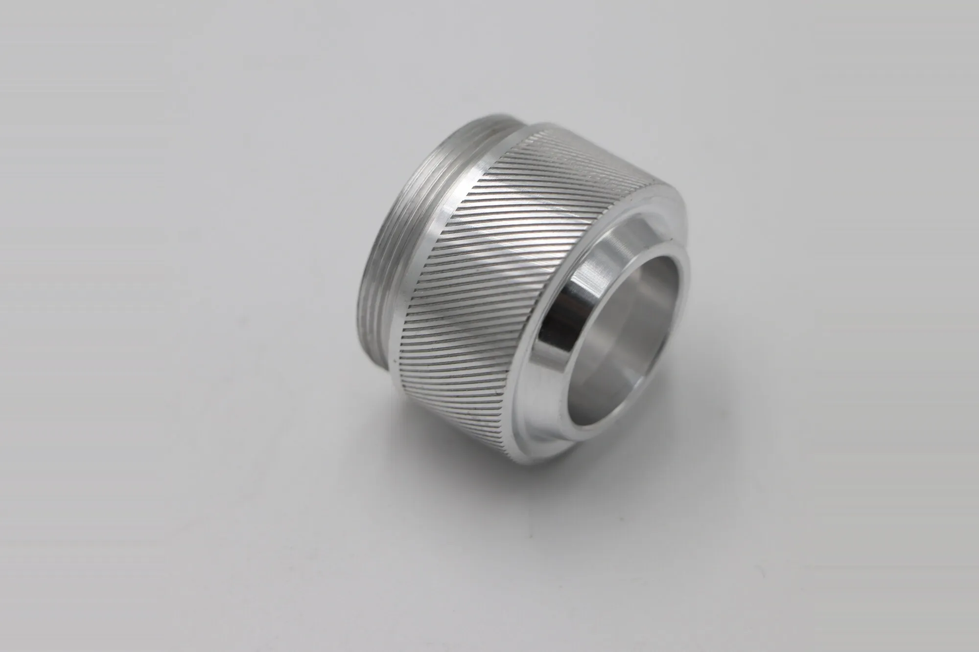 Close detail of a fine knurled thread collar machined in aluminum