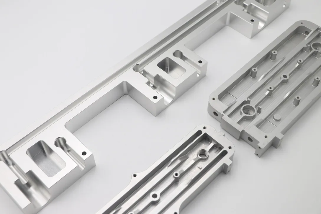 Long CNC milled aluminum frame rails with machined pockets and mounting features