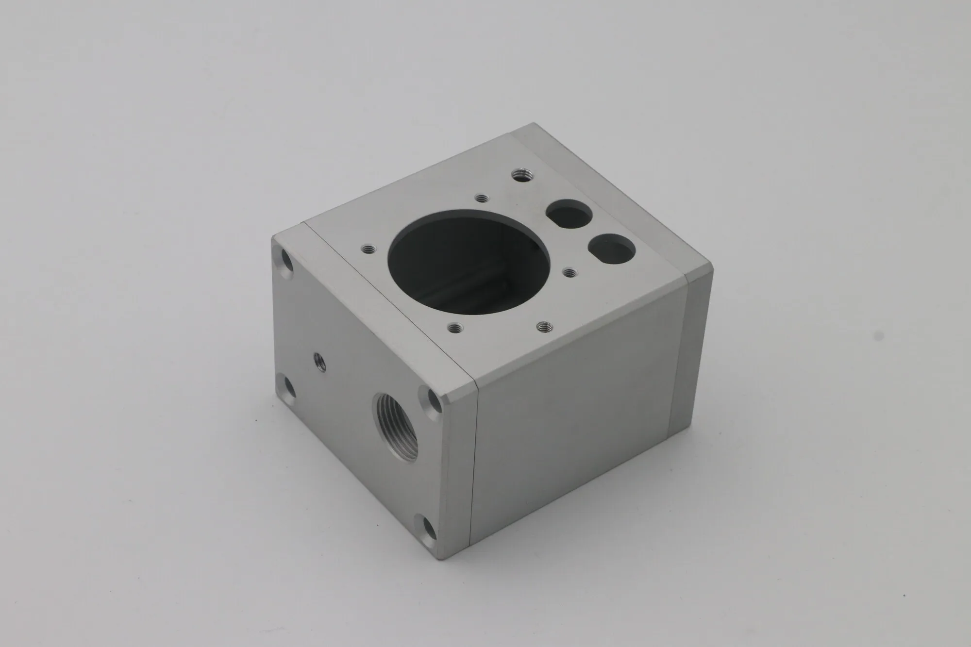 Machined aluminum junction box housing with large bore, threaded ports and mounting faces