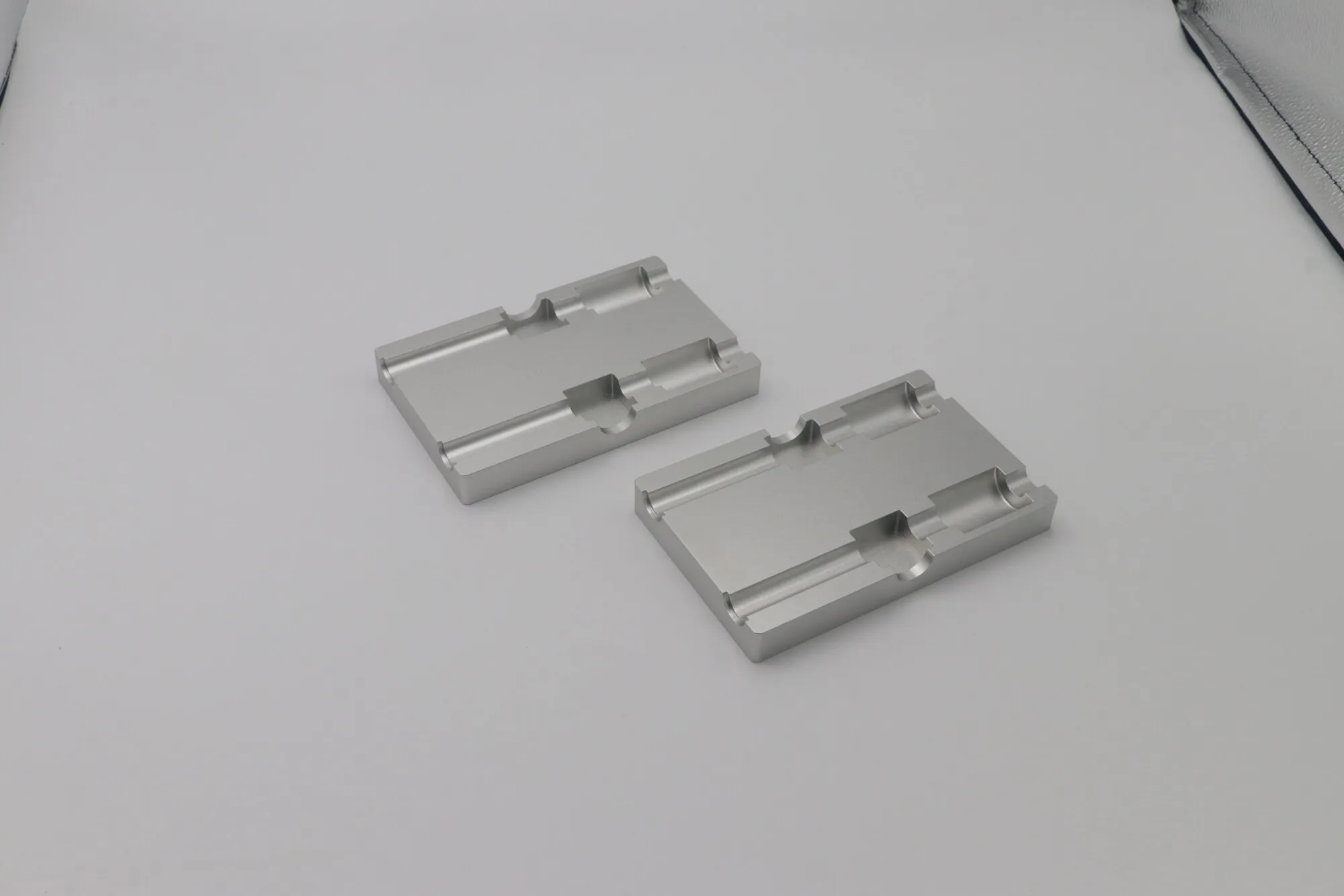 CNC milled steel hinge plates with machined bores and stepped faces