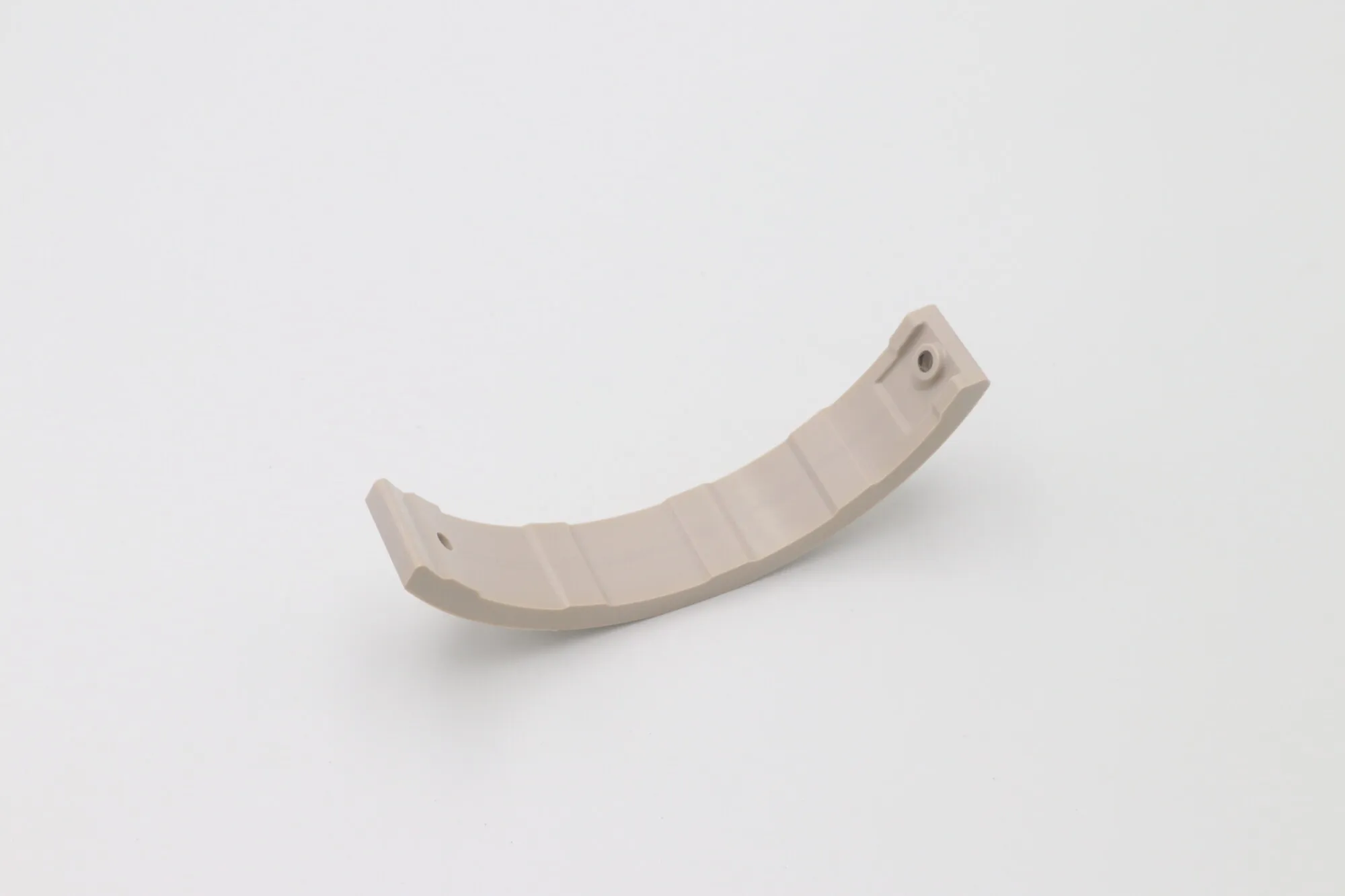 Machined PEEK arc segment with curved profile and mounting holes