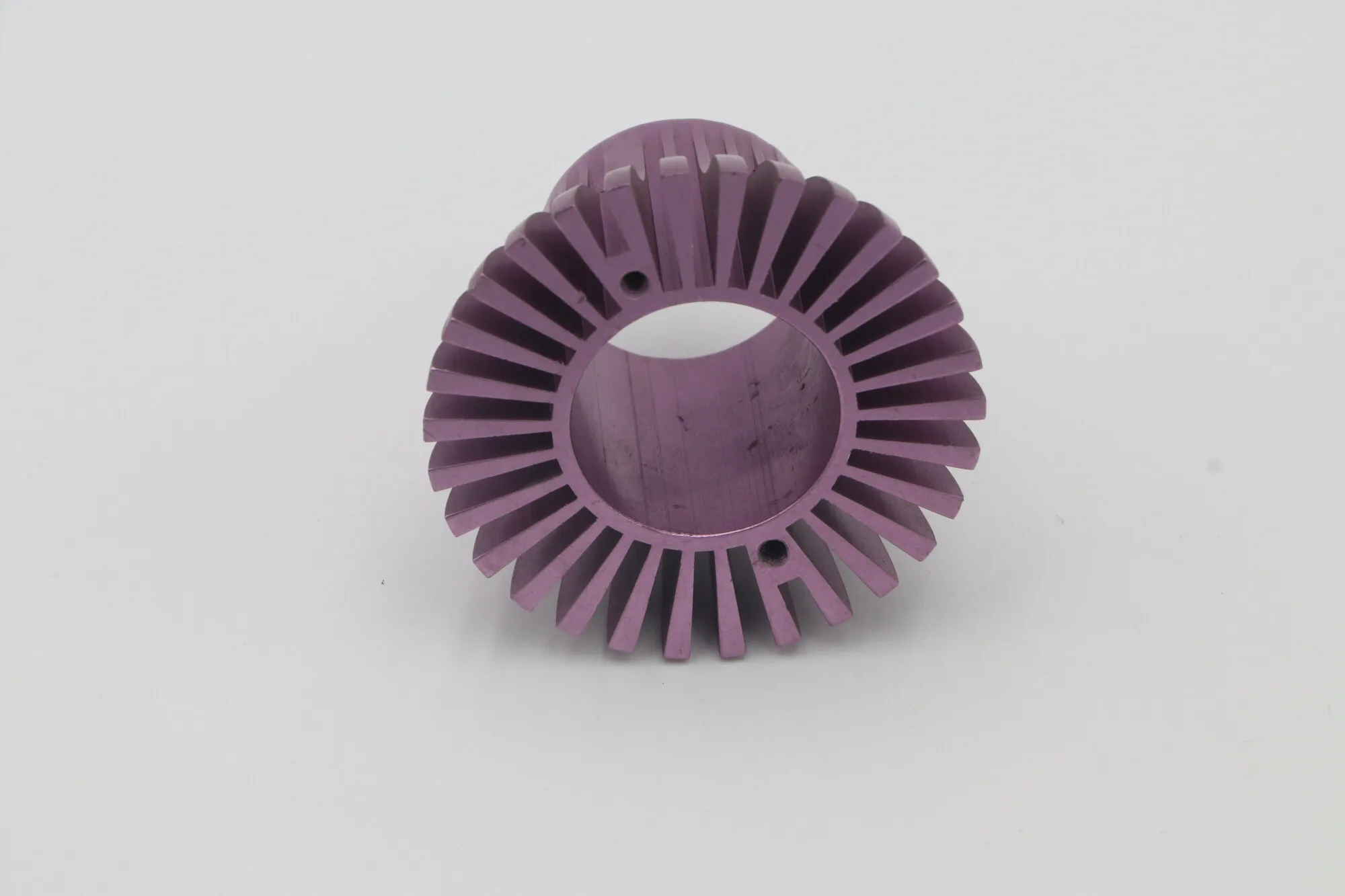 Close detail of radial fins on a purple anodized machined aluminum heat sink