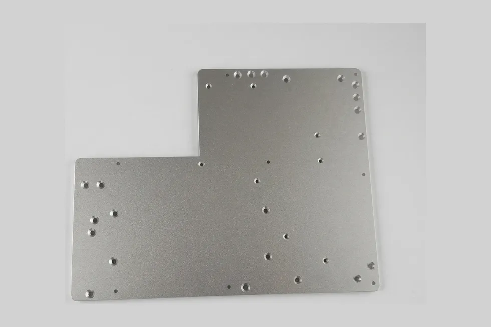 Flat sheet metal industrial panel with a machined hole pattern.
