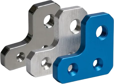 Machined metal brackets in three different surface finishes — nickel, bare aluminum, and blue anodized.