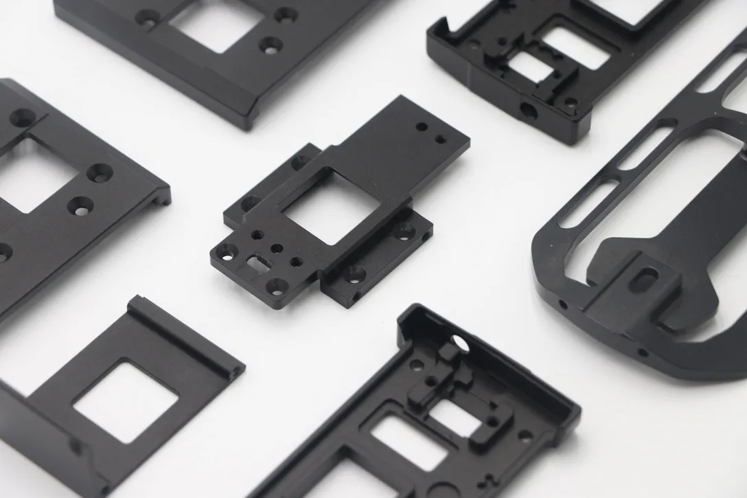 Group of thin-wall black anodized CNC milled aluminum plates and brackets