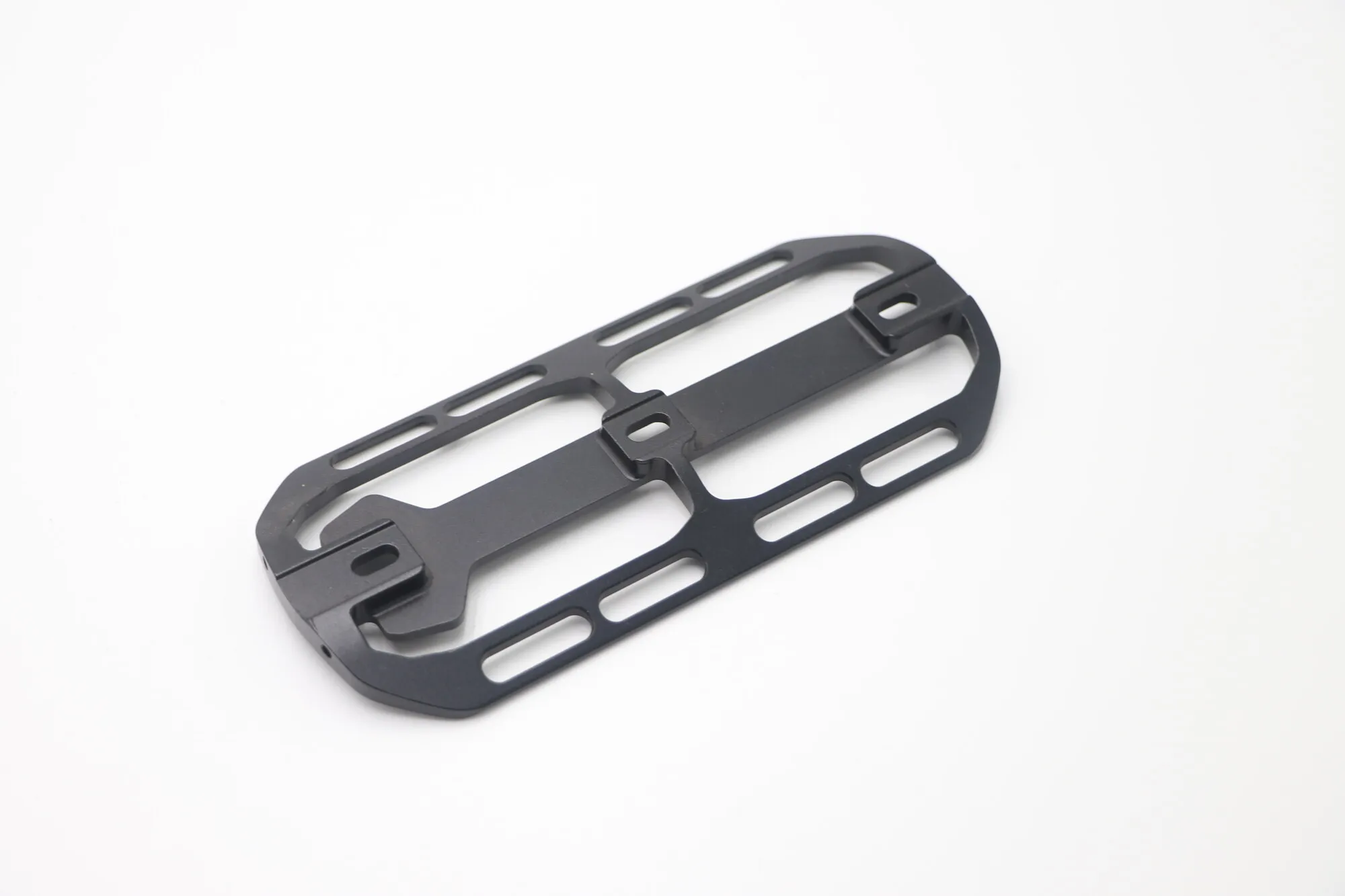 Thin-wall skeletonized black anodized aluminum plate with long milled slots