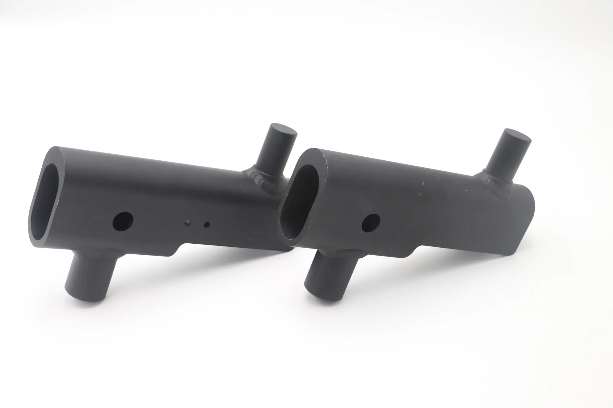 Pair of black anodized welded aluminum tube arms with machined bores