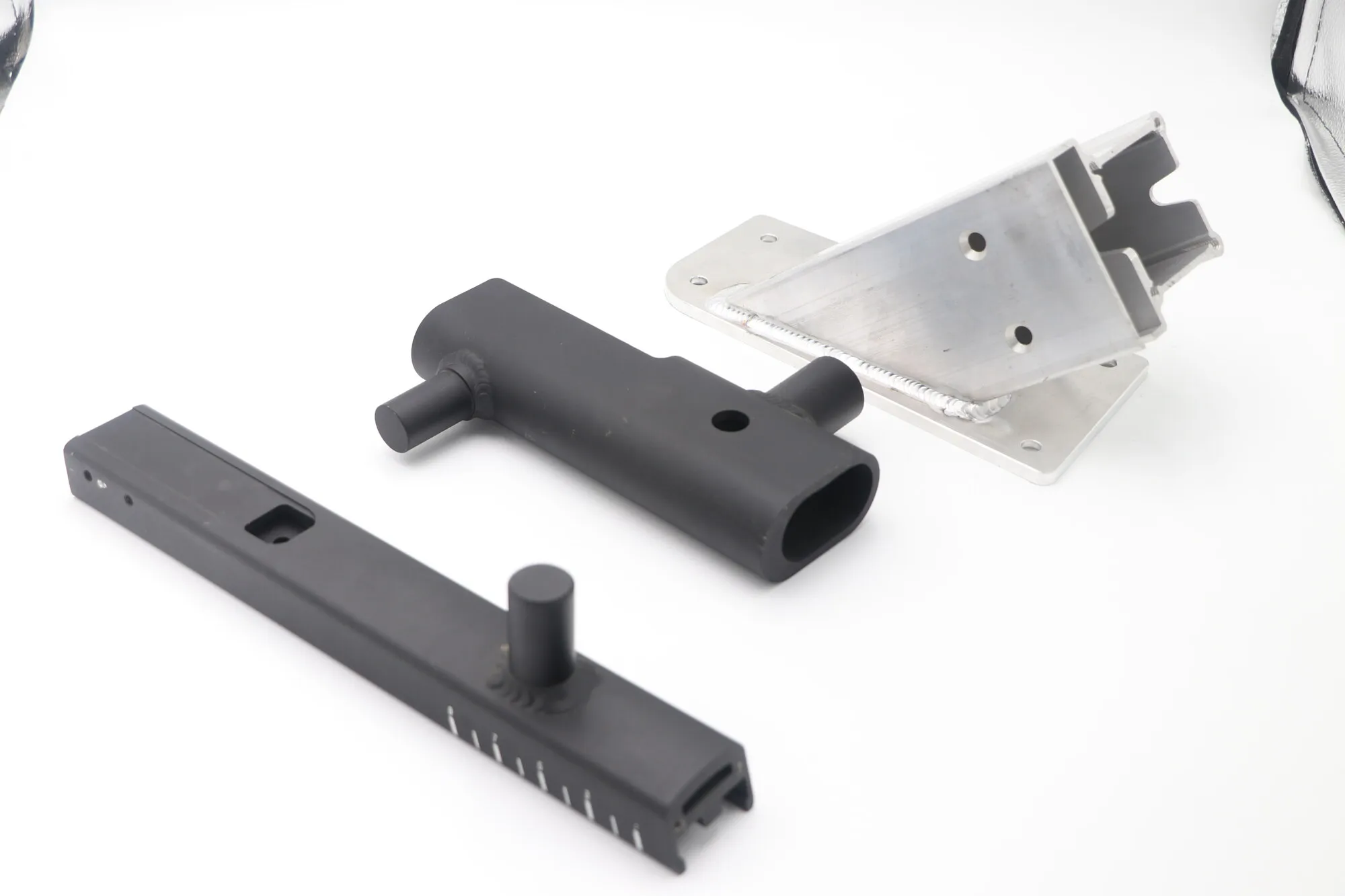TIG-welded and machined aluminum bracket assembly with a welded plate-to-channel joint and machined mounting face